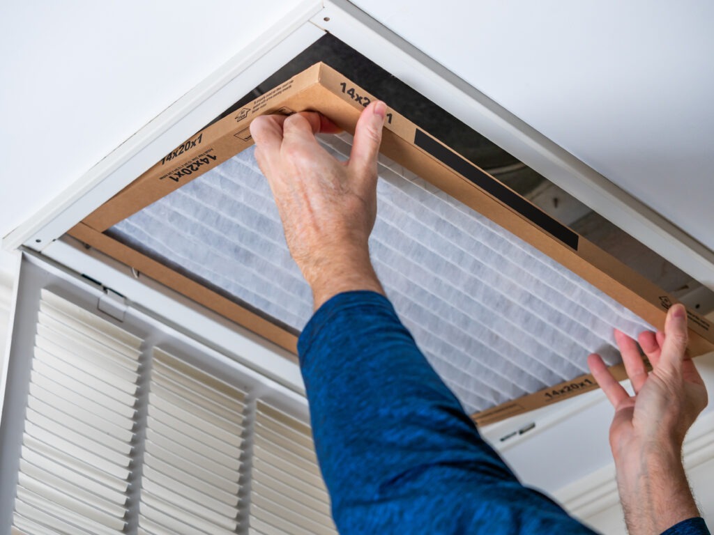 HVAC technician replacing a home air filter in Santa Clarita