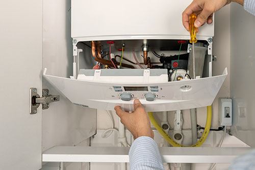Heating technician repairing a residential boiler in Santa Clarita