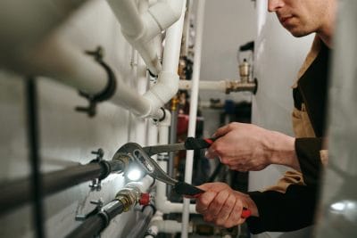 Technician inspecting commercial plumbing pipes in Santa Clarita
