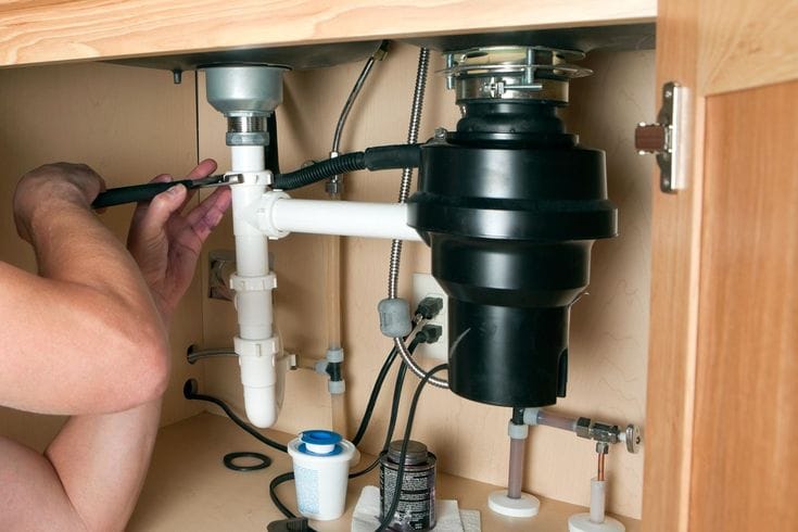 Plumber repairing a garbage disposal in Santa Clarita
